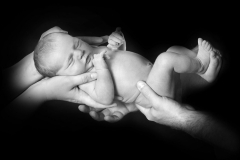 Nyfødt baby bæres af mor og far